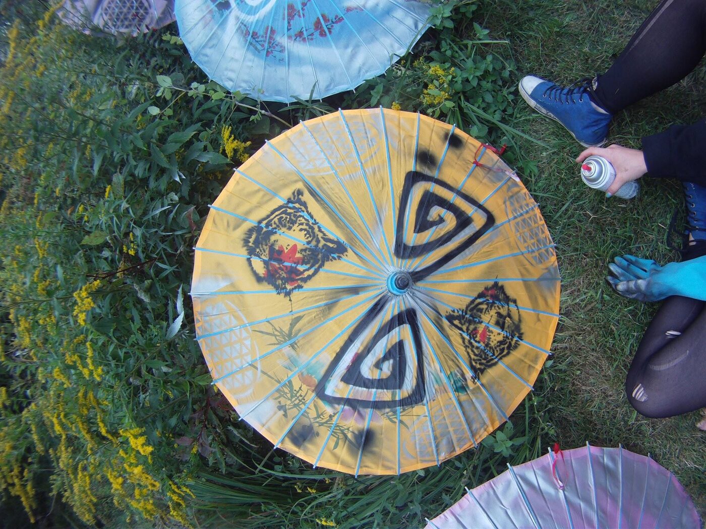 Les ombrelles de papier peintes, posées dans l'herbe.